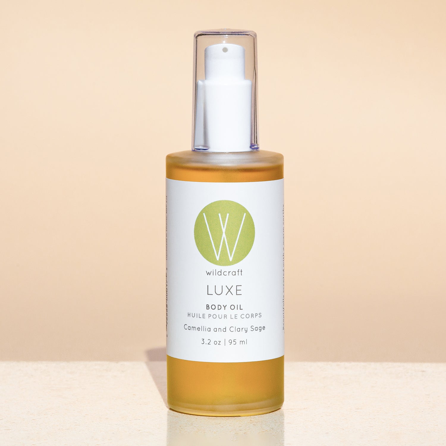 Bottle of Luxe Body Oil on a simple background
