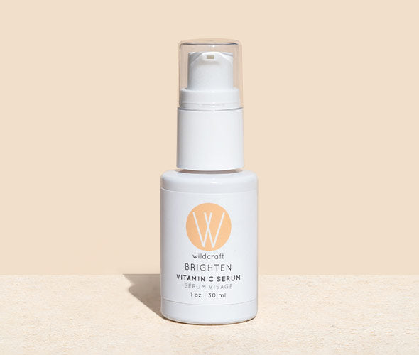 Bottle of Brighten Vitamin C Face Serum on a marble table.