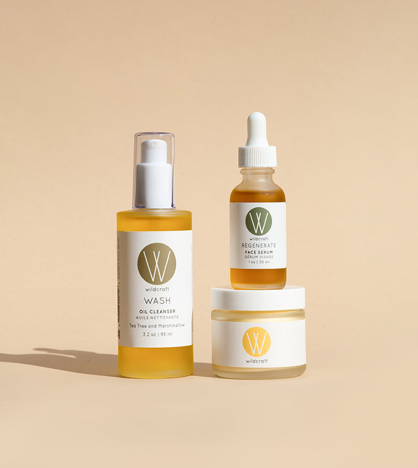 Wildcraft oil cleanser, face serum, and face cream skincare products stacked on top of each other on light backdrop